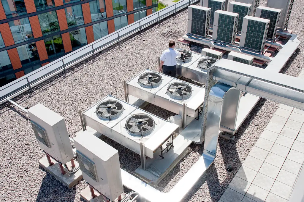 Multiple roof-mounted split air conditioning units installed across the roof of a commercial office space exceeding the 12kW threshold